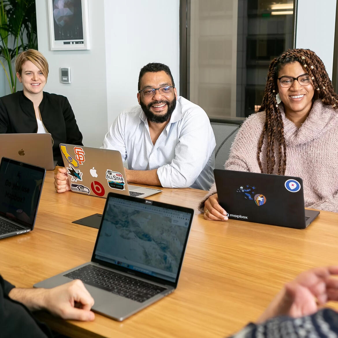 Team sitting at a large desk talking about a marketing project
